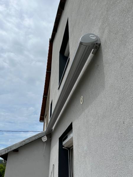 Détail du moteur SOMFY et capteur de vent EOLIS sur un store WINSOL ETANEL